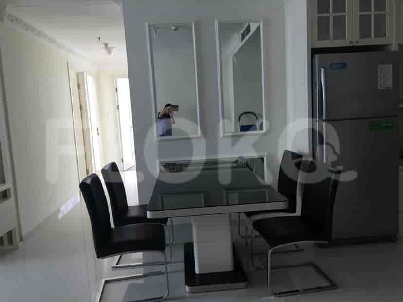A dining area with a table, chairs, and a kitchen.