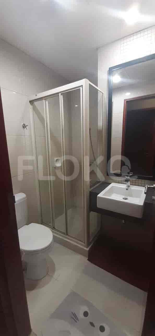 A modern bathroom with a glass shower enclosure, sink, and toilet.