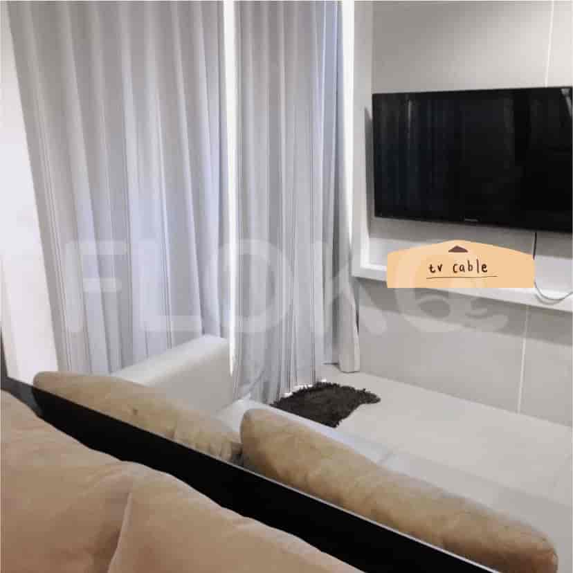 Living area with a sofa, TV, and window.