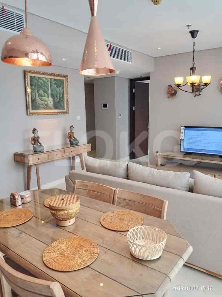 A dining and living area with a dining table, sofa, and decorative elements.