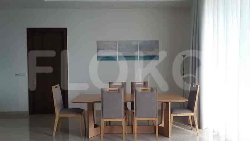 A dining room with a table, chairs, and artwork.