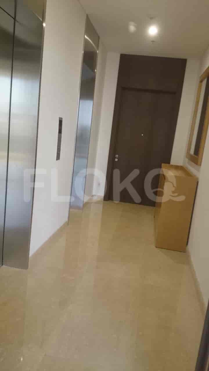 A hallway with an elevator and a cabinet.
