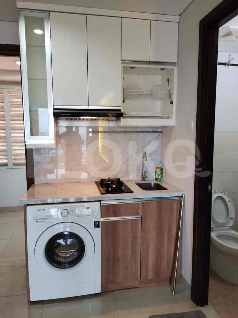 A small kitchen area with a washing machine and a cooktop.