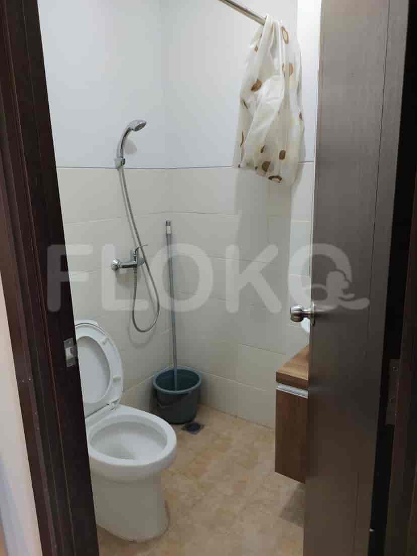 A compact bathroom with a toilet, sink, and shower.