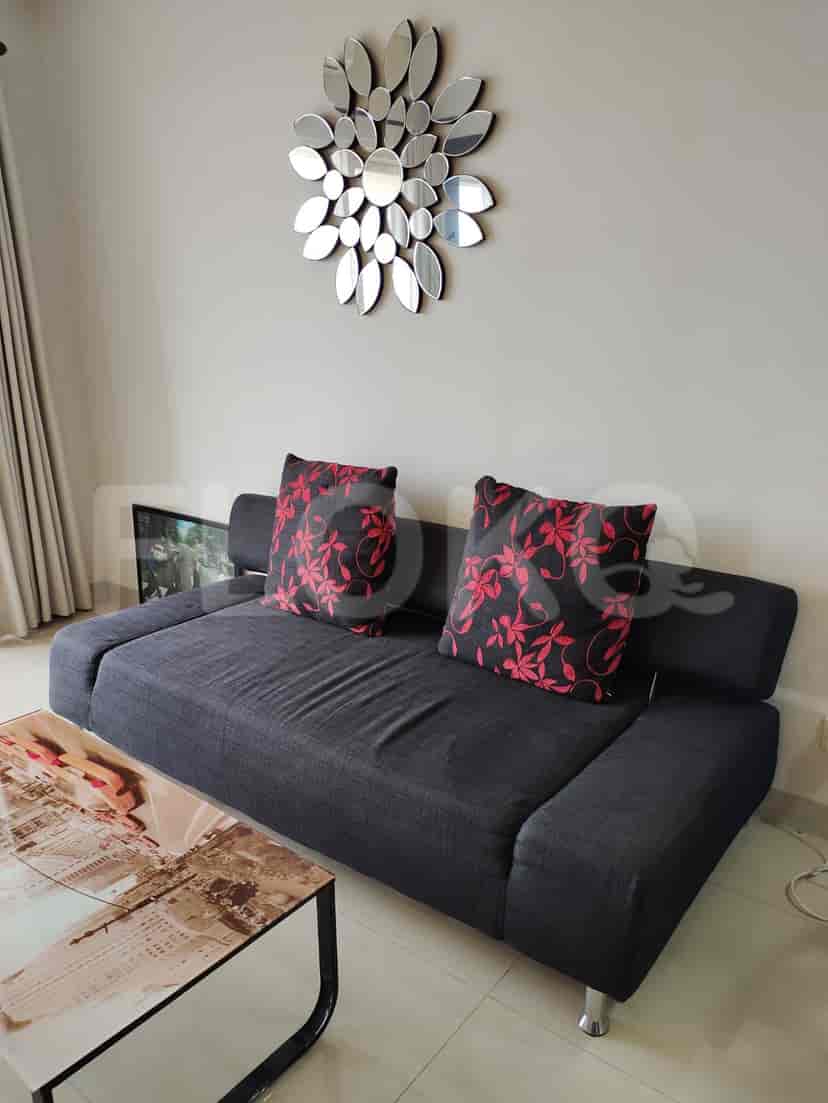 A living room with a dark grey sofa, decorative mirrors, and coffee table.