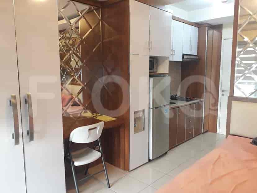 An apartment with a kitchen, bedroom with a bed, and a bathroom.