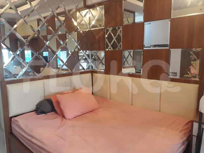 A bedroom with a double bed and mirrored wall.