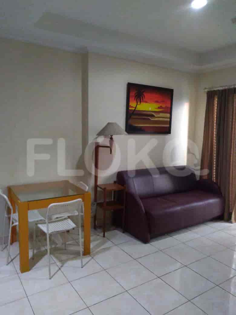 A living room with a dining area, a sofa, and artwork.