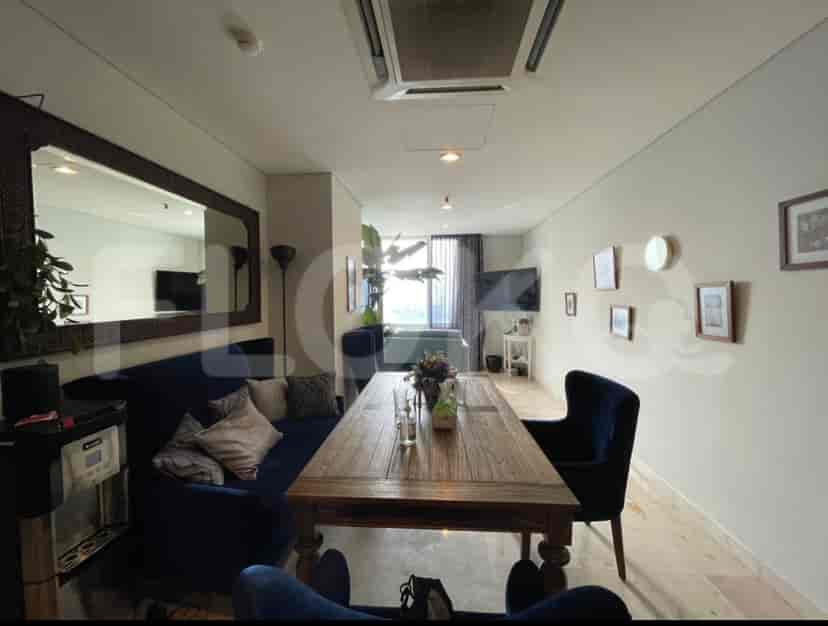 Spacious open-plan living and dining area with a dark wooden table, blue sofa, and mirror.