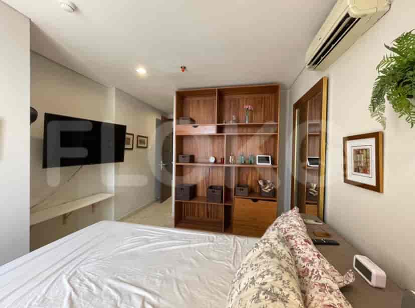 Bedroom with a bed, built-in cabinet, and wall-mounted TV.