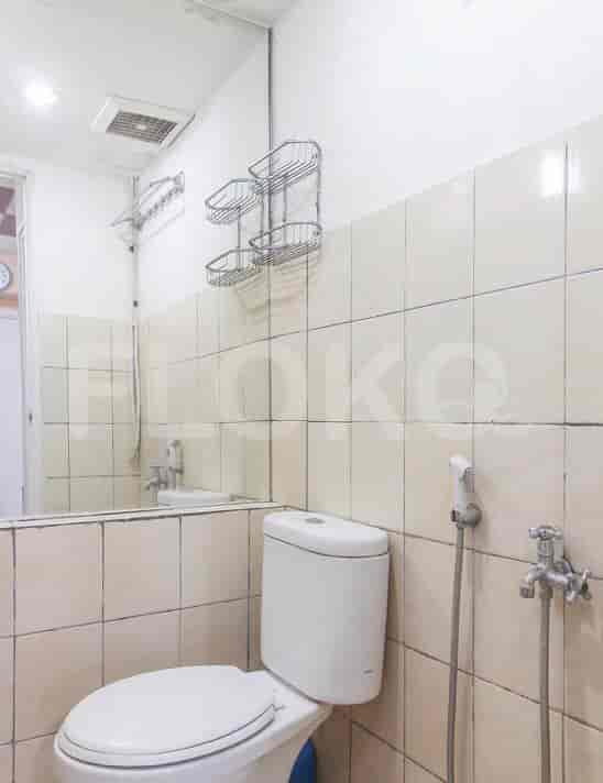 A compact bathroom with a toilet, sink, and shower area.