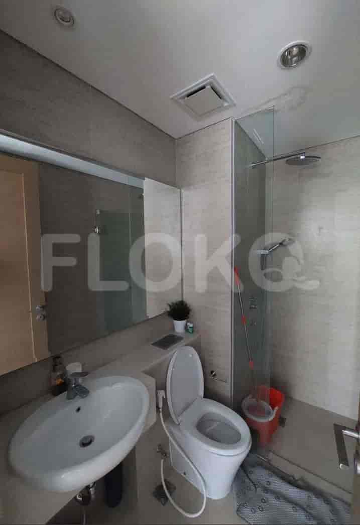 A modern bathroom with a shower, toilet, and sink.