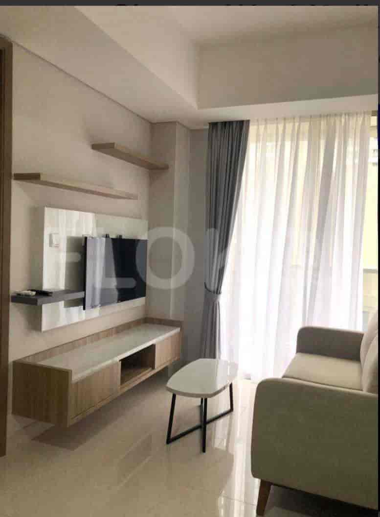 Living room with a TV, sofa, and shelves.