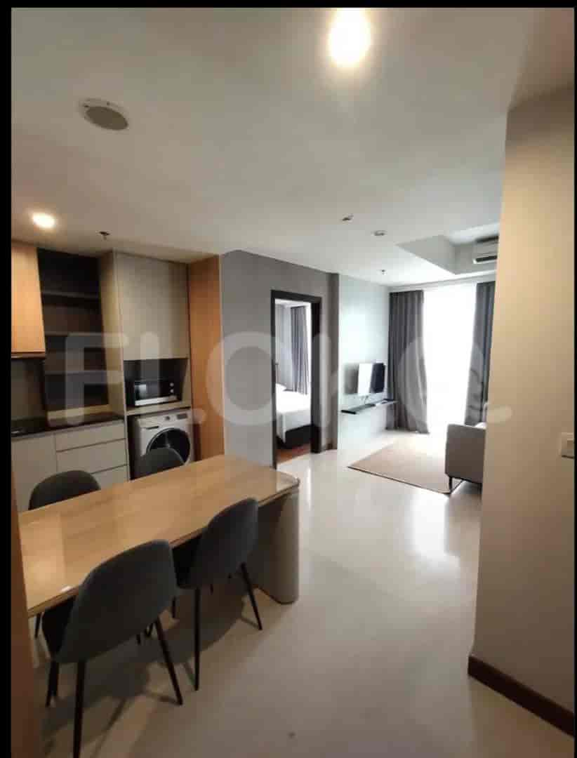 A modern kitchen with wooden cabinets, a dining table with chairs, and a washing machine.
