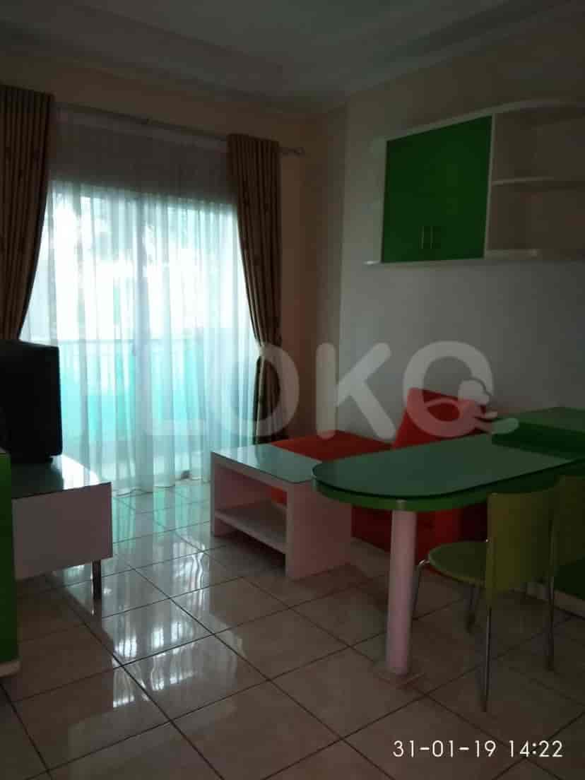 A compact living space with a sofa, TV, and a small dining table.