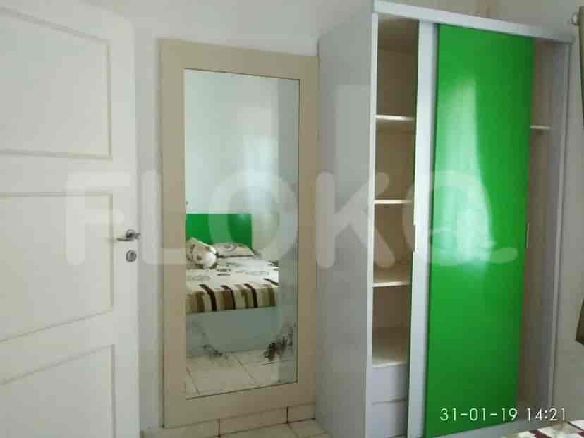A bedroom featuring a bed, wardrobe, and a mirror.