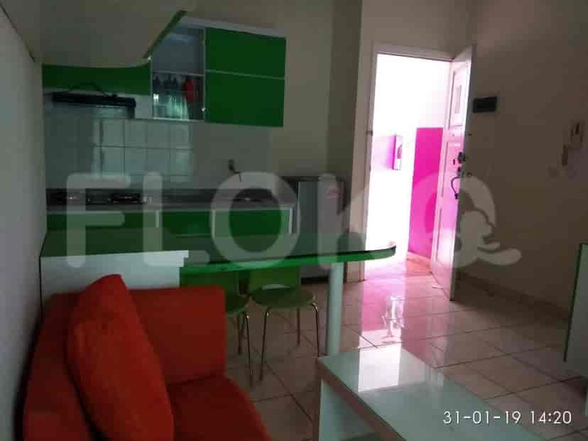 A combined kitchen and dining area with green cabinetry and a small dining table.