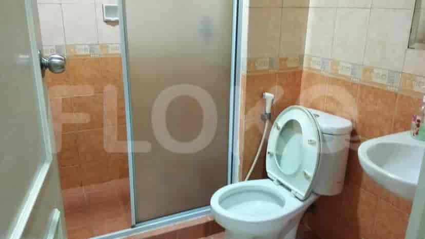 A small bathroom with a toilet, sink, and shower.