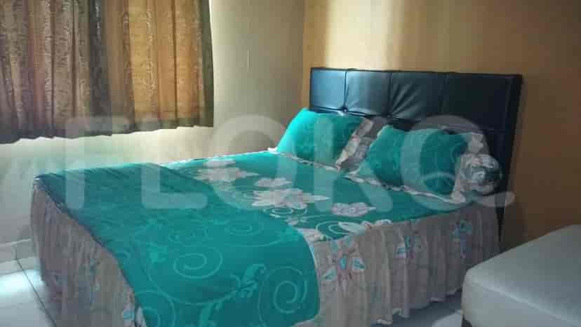 A bedroom with a bed, teal bedspread and curtains.