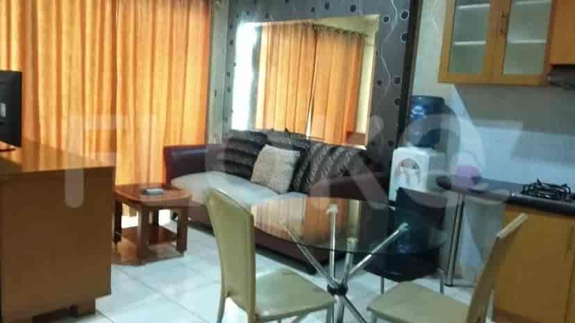 Living room with sofa, table, and kitchen visible.