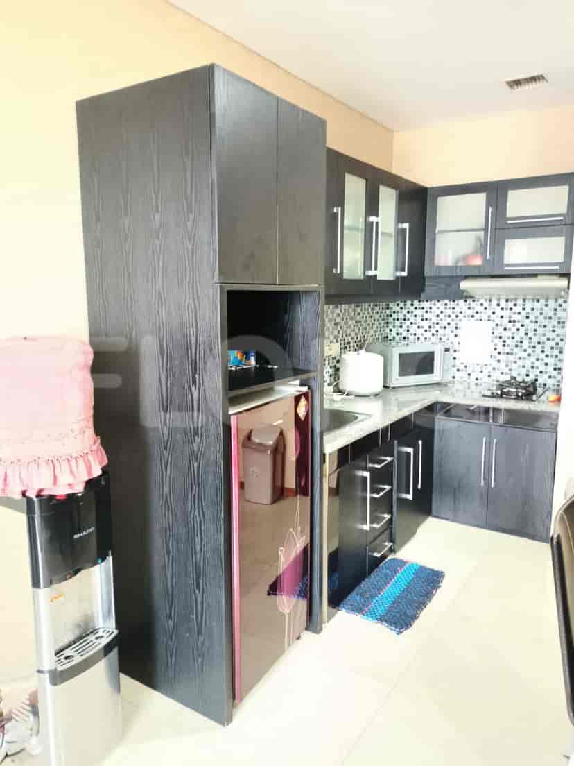 Kitchen with dark wooden cabinets, a refrigerator, and a microwave.