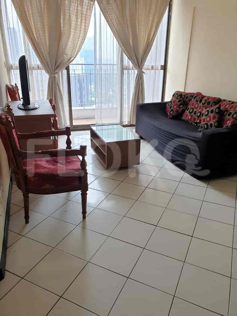 Living room featuring a sofa, chairs, and a glass-top table.