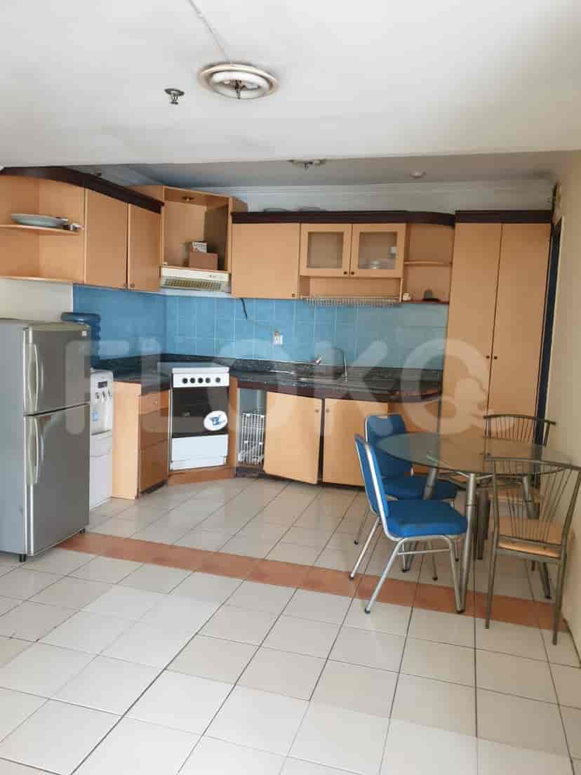Kitchen with wooden cabinets, tiled backsplash, and a dining area.