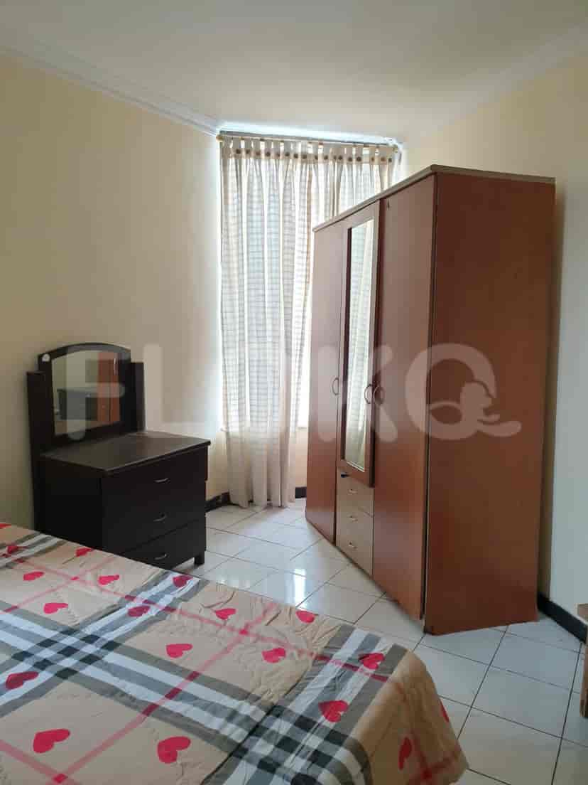 Bedroom featuring a bed with a patterned comforter, a dark dresser, and a large wooden wardrobe.