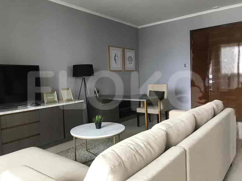 Ruang tamu yang dirancang dengan baik dengan sofa, TV, dan meja kopi.