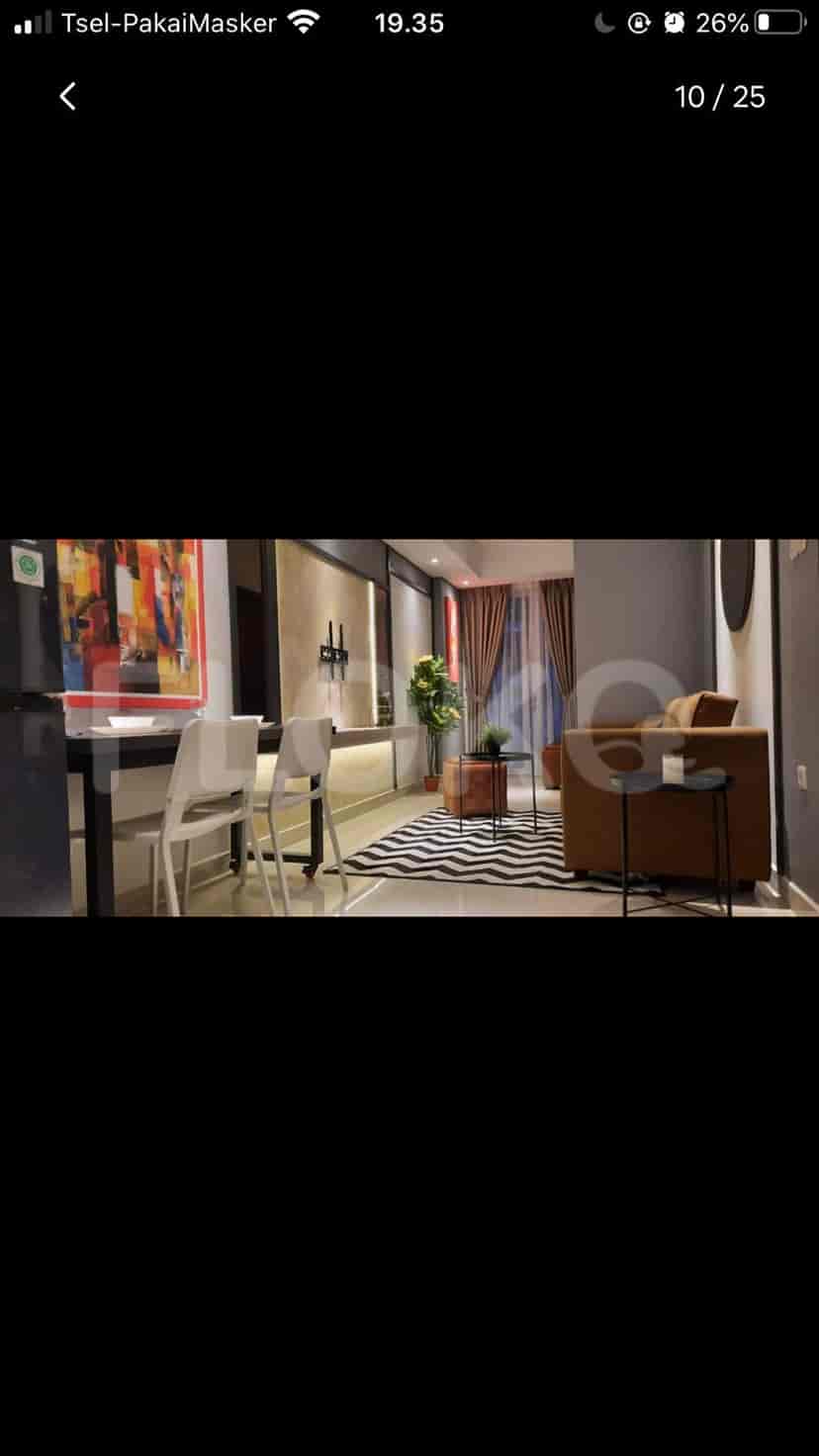 Living room featuring a sofa, dining area, and decorative art.