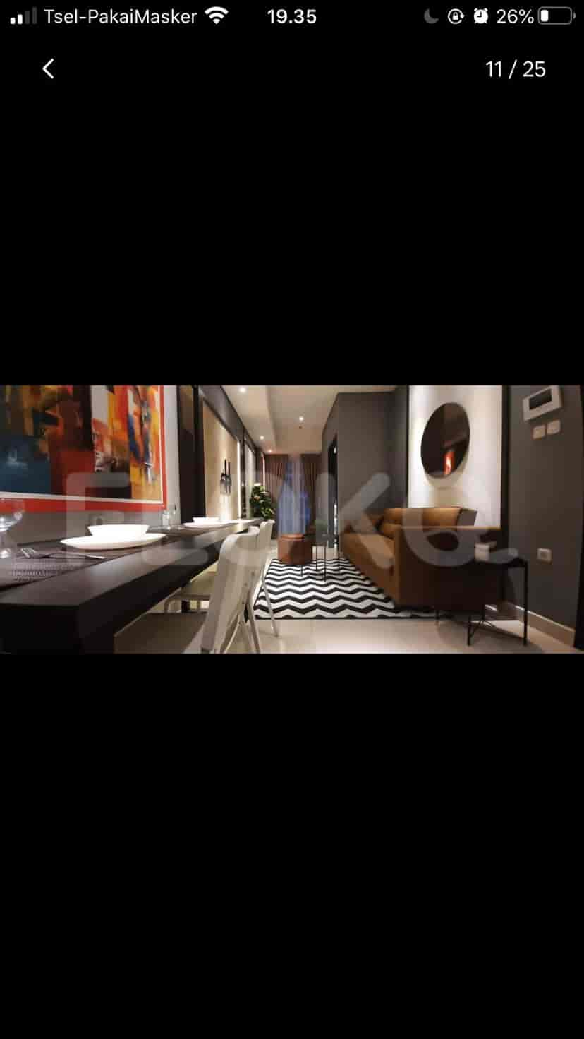 Living room featuring a sofa, dining area, and decorative art.