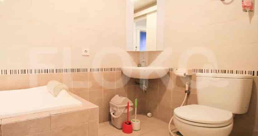 A bathroom with a white toilet, sink, and a small bathtub.