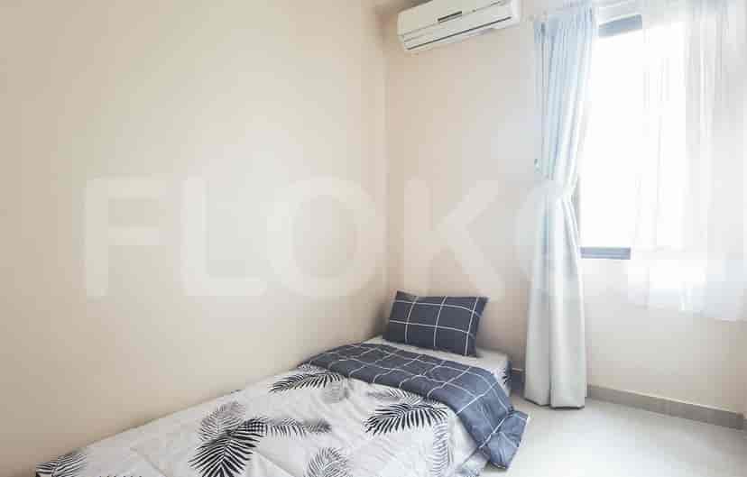 Kamar tidur kecil dengan tempat tidur tunggal, sprei bermotif, dan AC yang dipasang di dinding.