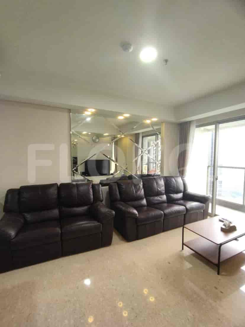 Living room with two brown leather sofas, a mirrored wall, and a coffee table.