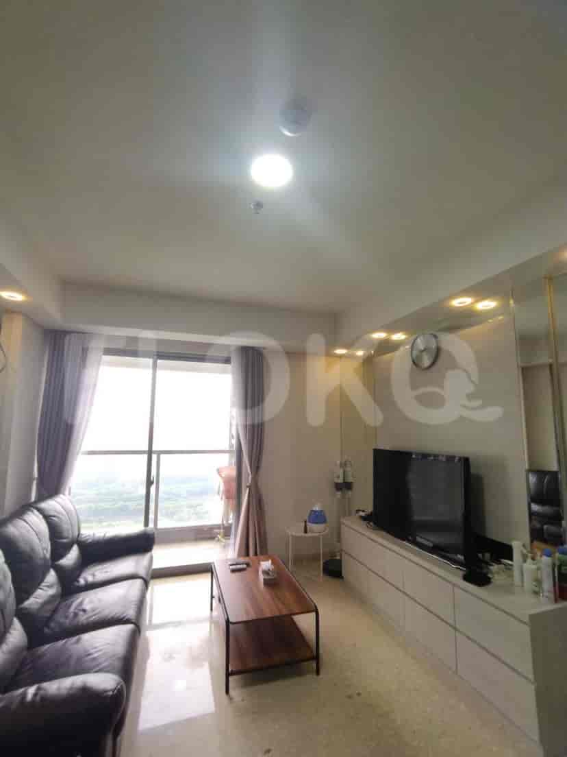 Living room with a black sofa, mirrored wall, and a smart TV.