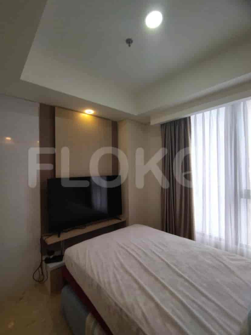 Bedroom with a bed, a large television, and a built-in cabinet.