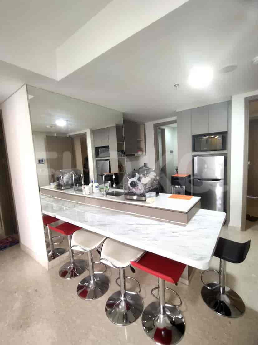 Kitchen with a bar, stools, and a refrigerator.