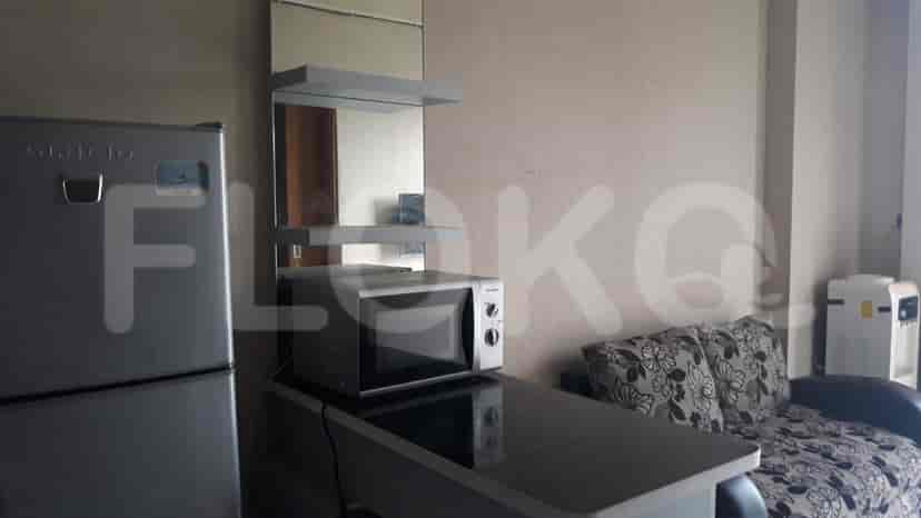 Compact living space with a refrigerator, microwave, and small kitchen counter.