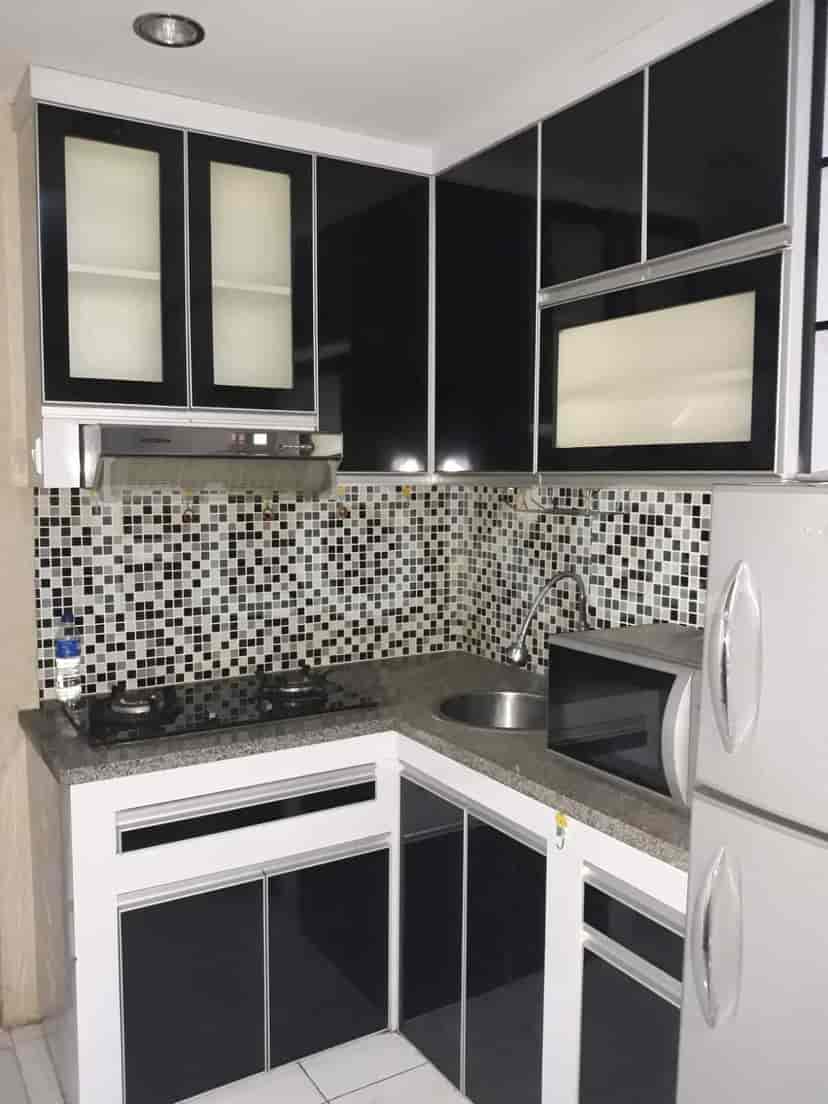 Compact kitchen with cabinets and a cooking surface.