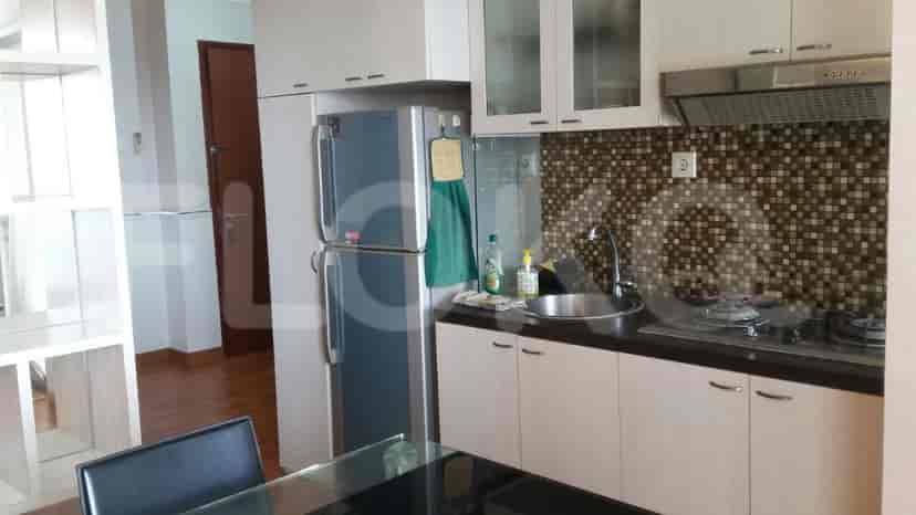 A modern kitchen with a refrigerator, cabinets, a stove, and a sink.