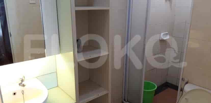 A bathroom with a sink, mirror, and shower area.