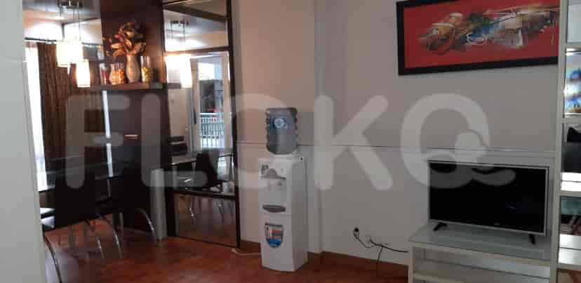 A dining area featuring a dining table, chairs, water dispenser, and decorative items.