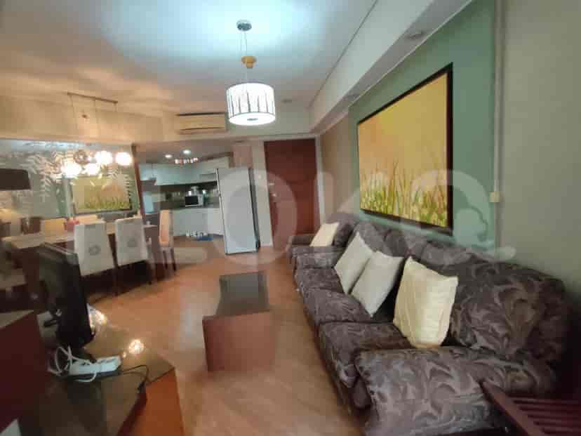 Living room with a sofa, TV, dining table, and open kitchen view.