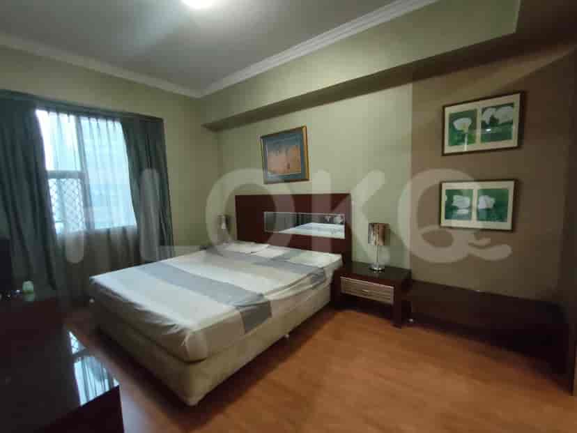Spacious master bedroom with a large bed, nightstands, and artwork.