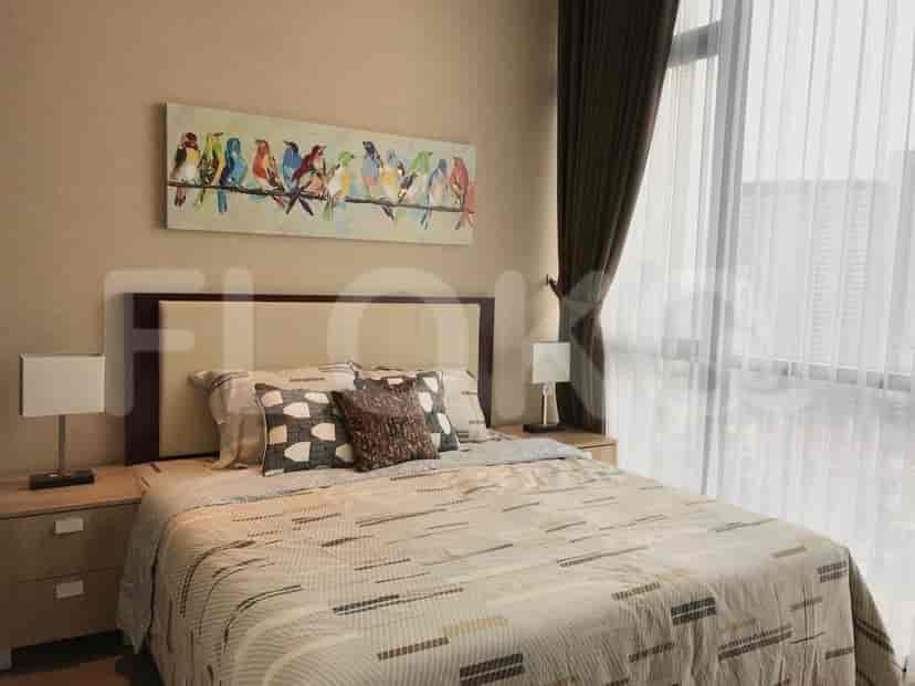 Cozy bedroom with a king-size bed, artwork, and large windows.