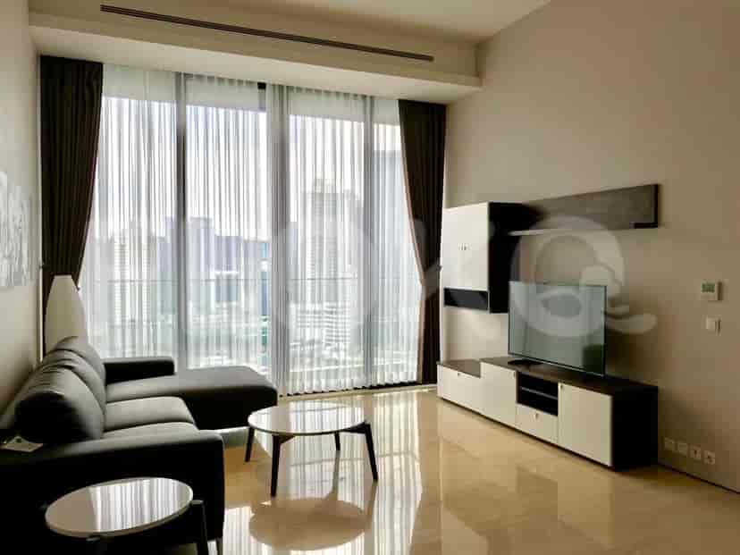 Living room with an L-shaped sofa, smart TV, and large windows.