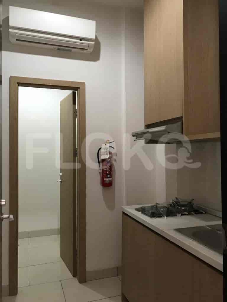 Compact kitchen with light-colored wooden cabinetry, a gas stove, and a fire extinguisher.