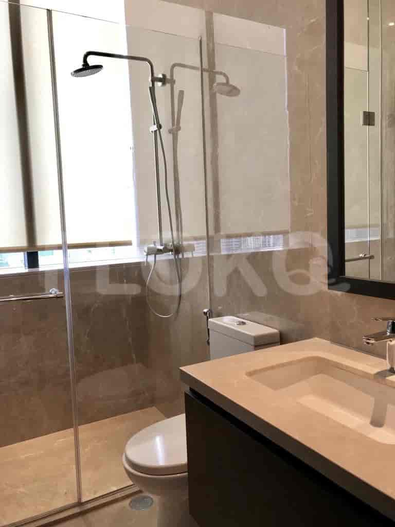 Modern bathroom with a glass-enclosed shower, sink, and toilet.