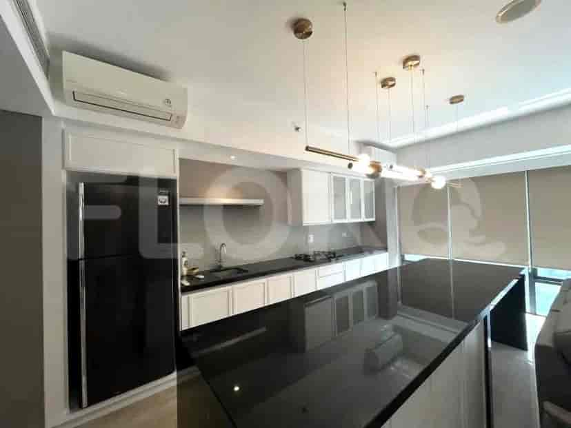 Dapur modern dengan lemari putih, meja island hitam, dan kulkas hitam.