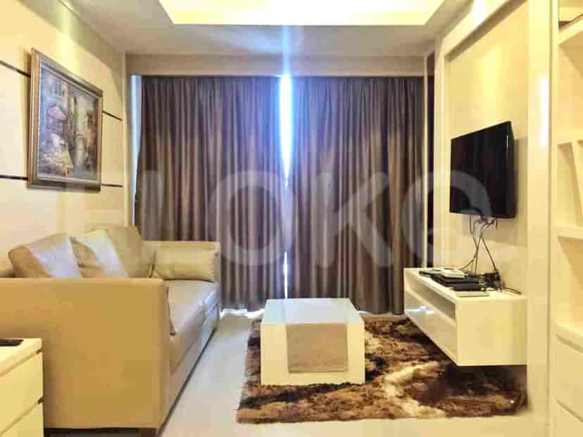 A modern living room with a beige sofa, coffee table, and TV.